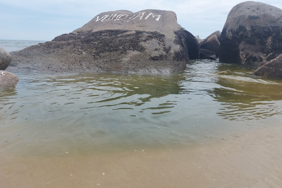 Nước ở khu vực miệng ống xả thải của HTX Bảo An Phú có màu xanh đen, hối thối hòa vào nước biển. Ảnh: Trần Tuấn.