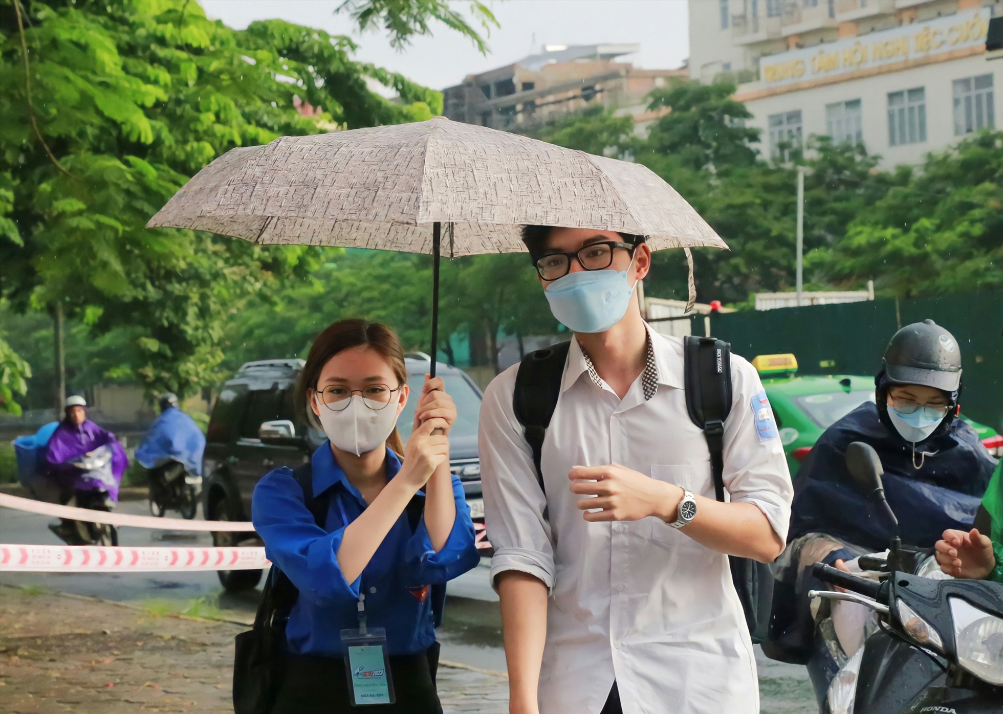 Tại Hà Nội, từ sáng sớm ngày 28.6 đã xuất hiện các cơn mưa. Thí sinh đến điểm thi được thanh niên tình nguyện hỗ trợ vào phòng thi. Ảnh: Minh Hà