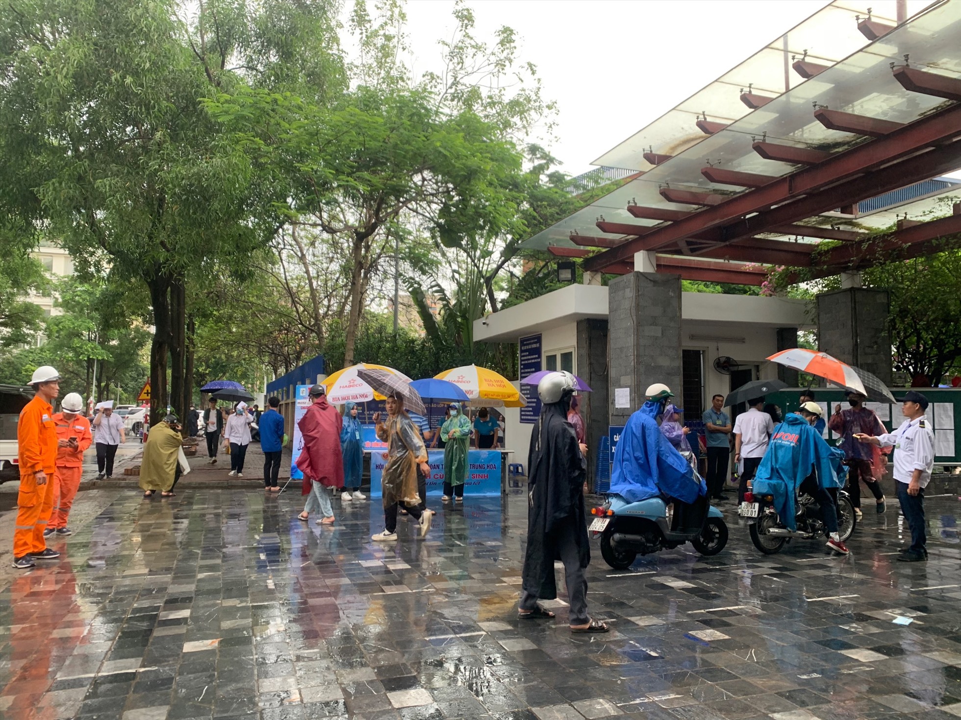Theo ghi nhận tại Hà Nội, thời tiết sáng sớm nay có mưa nhỏ. Các thí sinh và phụ huynh khi di chuyển tới điểm thi phải sử dụng áo mưa và ô.