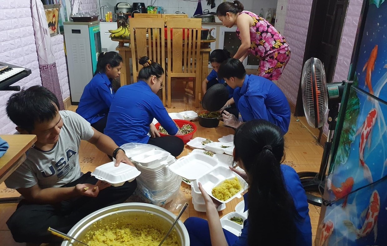 Các đoàn viên và giáo viên nấu các suất cơm miễn phí cho thí sinh ở điểm thi Trường THPT Hướng Hóa. Ảnh: Chí Thành.