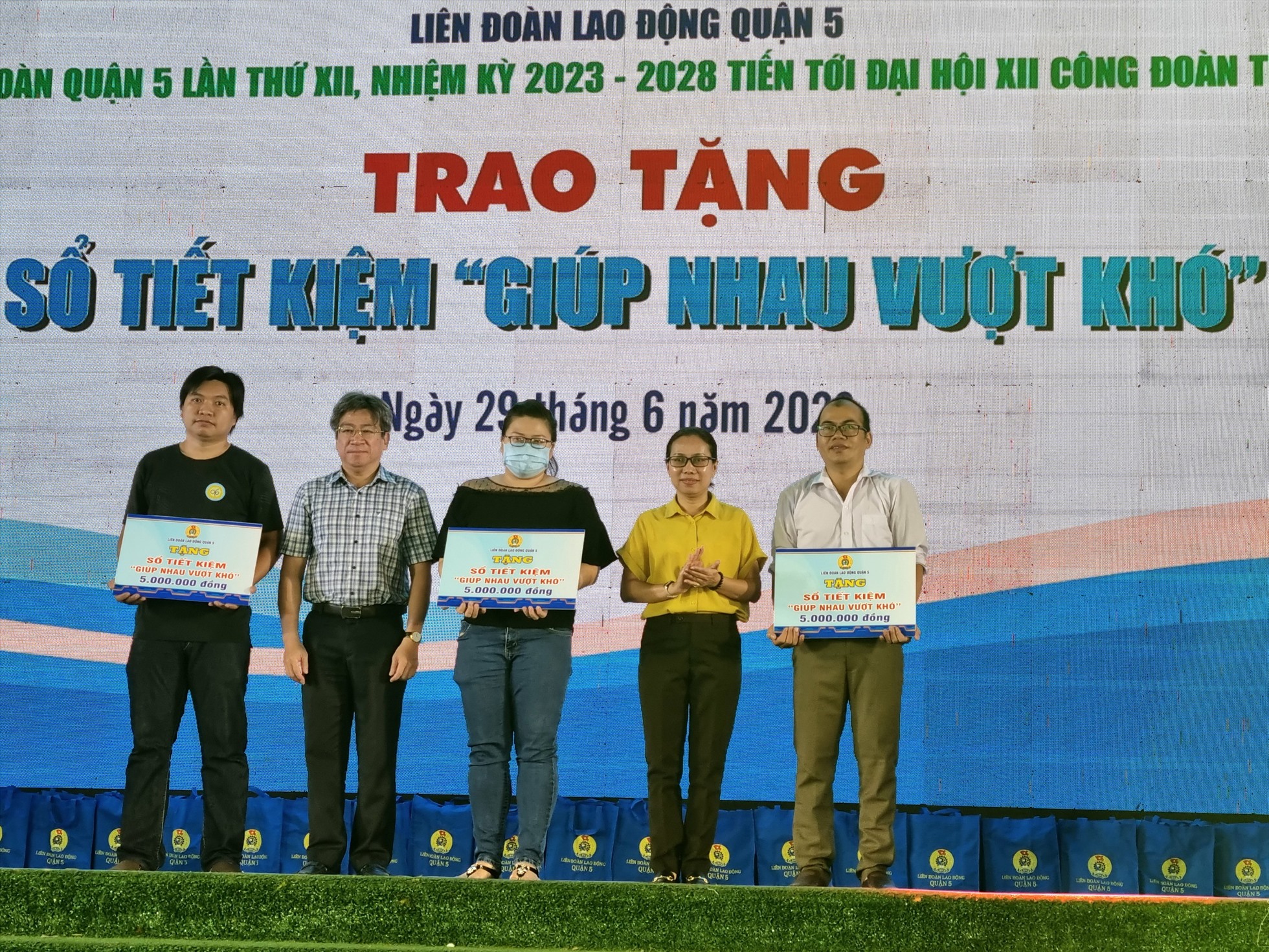 Đại diện LĐLĐ TP Hồ Chí Minh và UBND quận 5 trao tặng sổ tiết kiệm “Giúp nhau vượt khó” cho các CNLĐ bị bệnh nan y, hiểm nghèo. Ảnh: Nam Dương