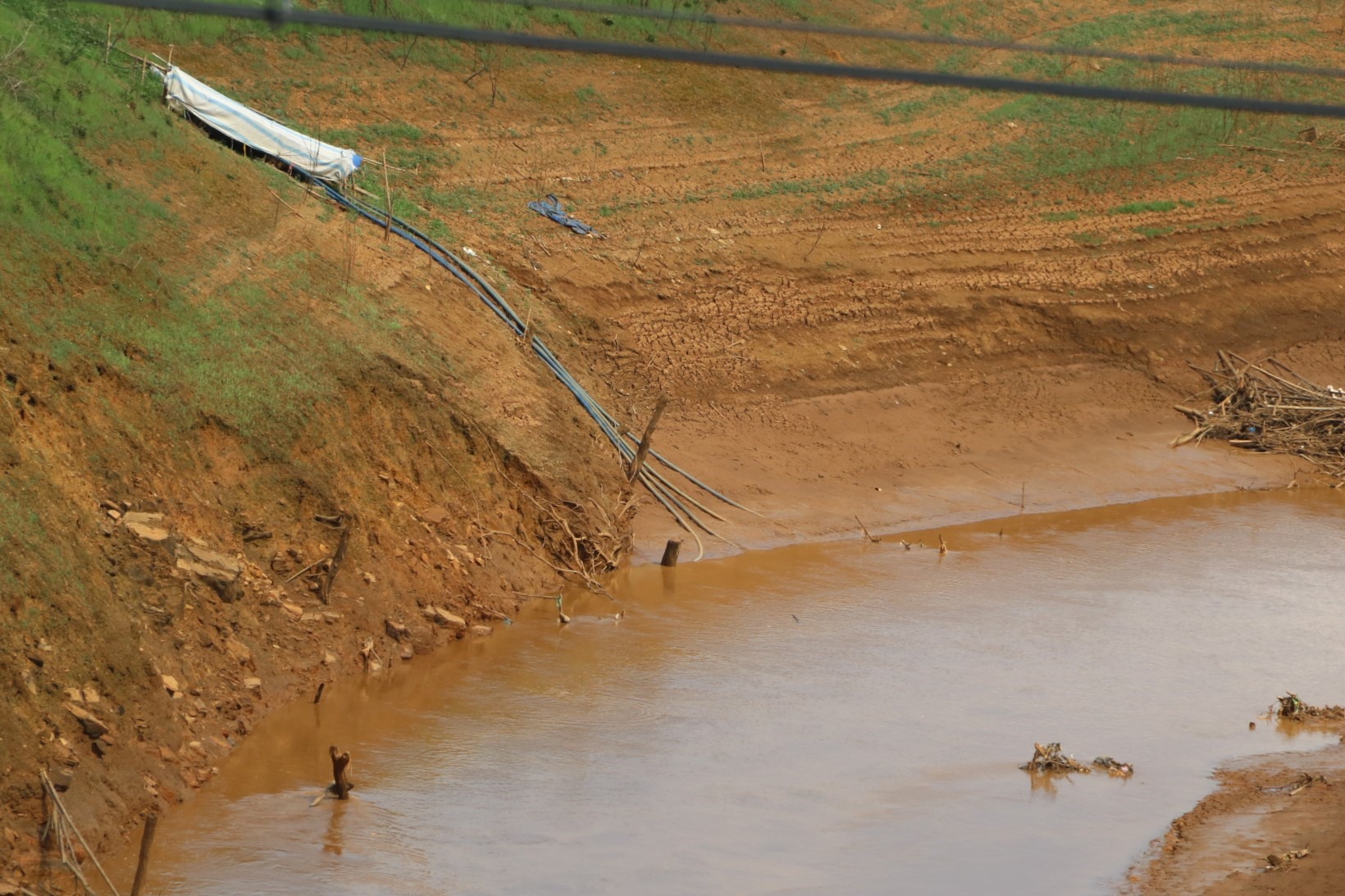 Hồ cạn nước gây khó khăn cho người dân sản xuất nông nghiệp, không có nước tưới cho cây trồng. Các ống hút nước đặt sâu xuống dưới các dòng chảy vất vả lấy nước tưới.