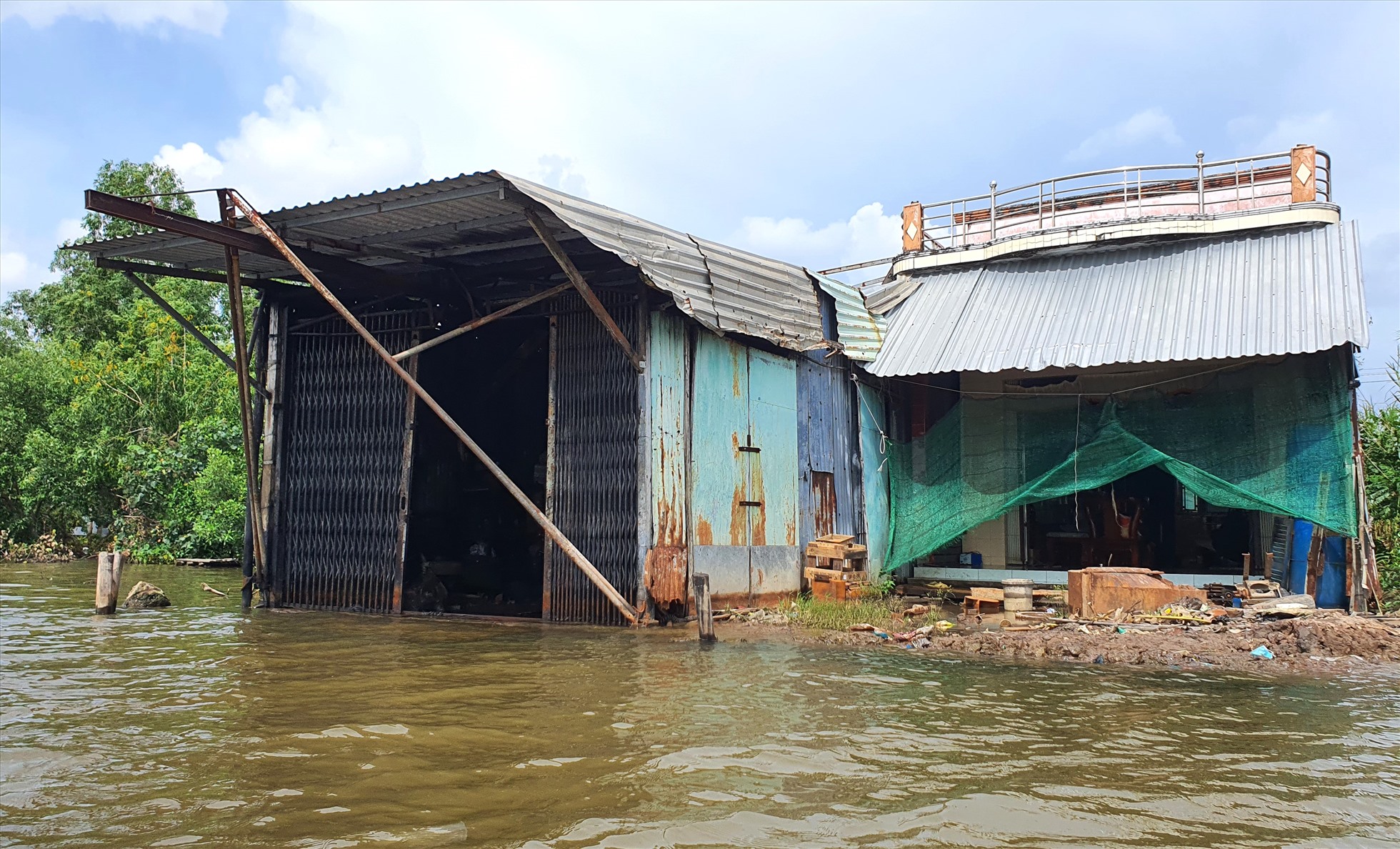 Nhà ven sông tại tỉnh Cà Mau nguy cơ đối mặt với sạt lở đất mỗi khi đến mùa mưa, bão. Ảnh: Nhật Hồ
