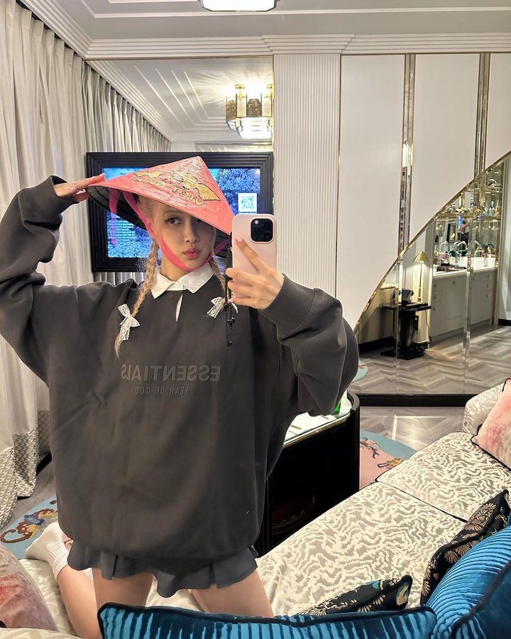 Rosé (Blackpink) nhí nhảnh tạo dáng cùng nón lá màu hồng trong khách sạn. Ảnh: Instagram nhân vật