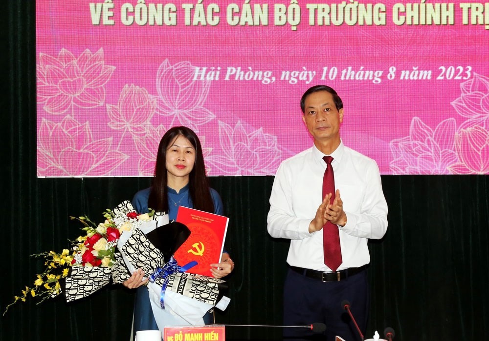 Ông Đỗ Mạnh Hiến, Phó Bí thư Thường trực Thành ủy trao Quyết định và tặng hoa cho bà Trần Thị Thanh Minh. Ảnh: Cổng TTĐT Hải Phòng