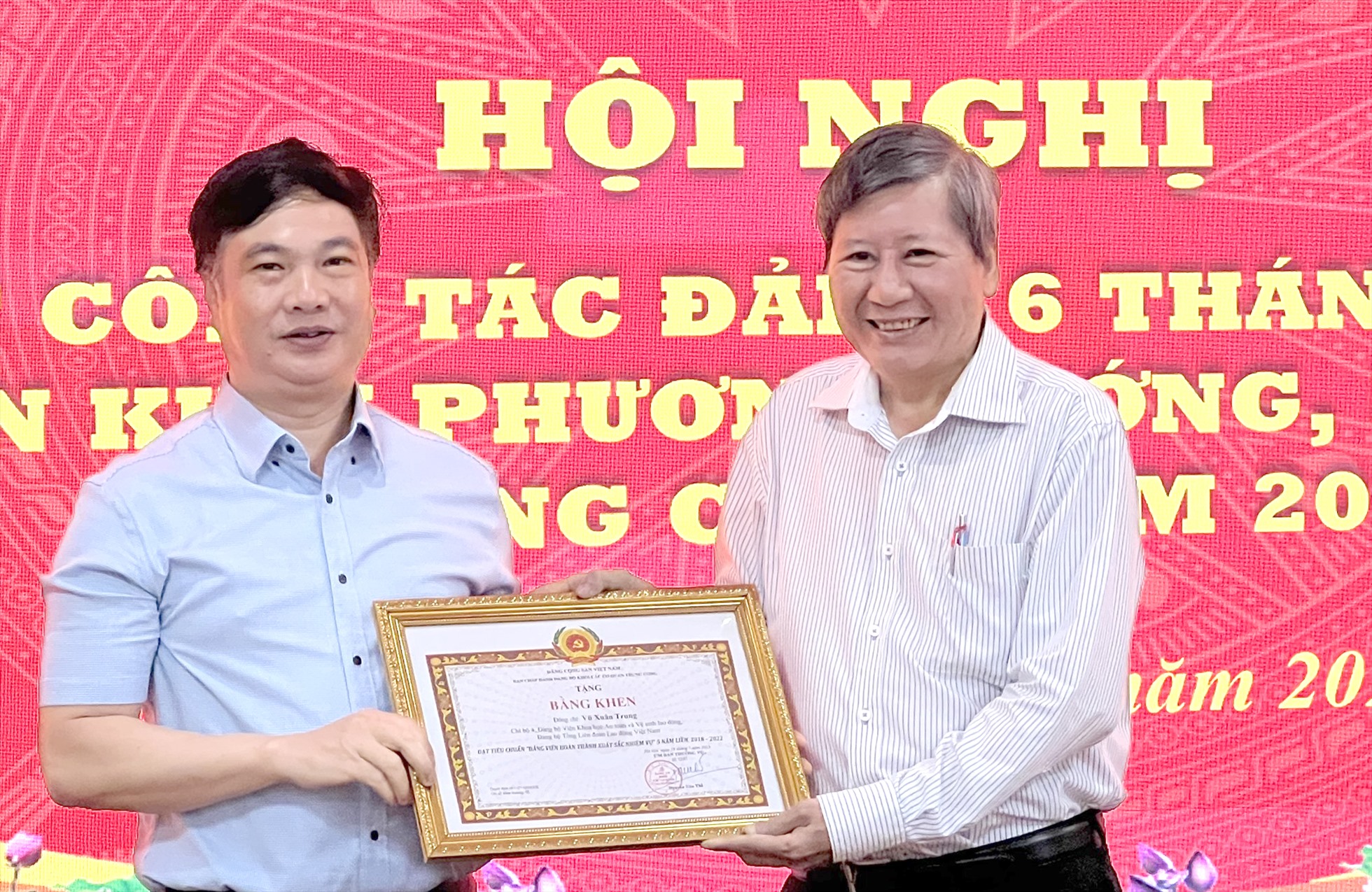 Đồng chí Vũ Xuân Trung (bên trái) nhận Bằng khen của Đảng uỷ Khối. Ảnh: Kiều Vũ
