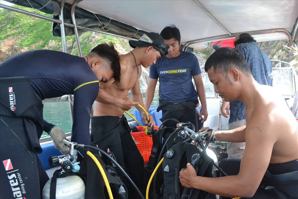 Các thợ lặn chuẩn bị dụng cụ để xuống nước lặn tìm san hô bị gãy, vỡ. Ảnh: Châu Tường