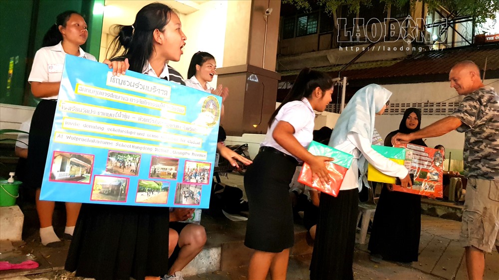 Một nhóm học sinh đang vận động quyên góp ủng hộ quỹ học bổng cho nhà trường tại khu chợ đêm Bazzar. Ảnh: Lê Phi Long