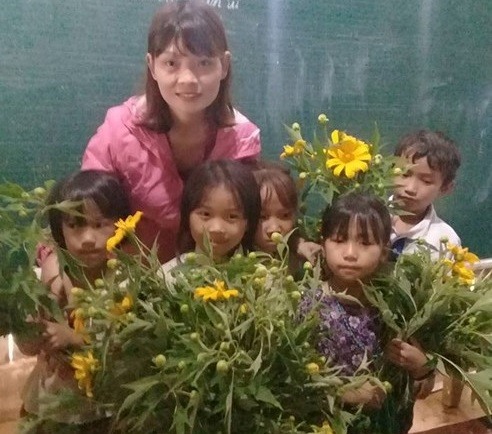 Cô giáo vùng cao hạnh phúc khi nhận được những bó hoa dã quỳ của học trò nhỏ. Ảnh: NVCC