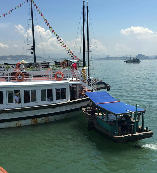 Một chiếc thuyền bán hàng rong cặp vào tàu du lịch ép du khách mua hàng trên vịnh Hạ Long