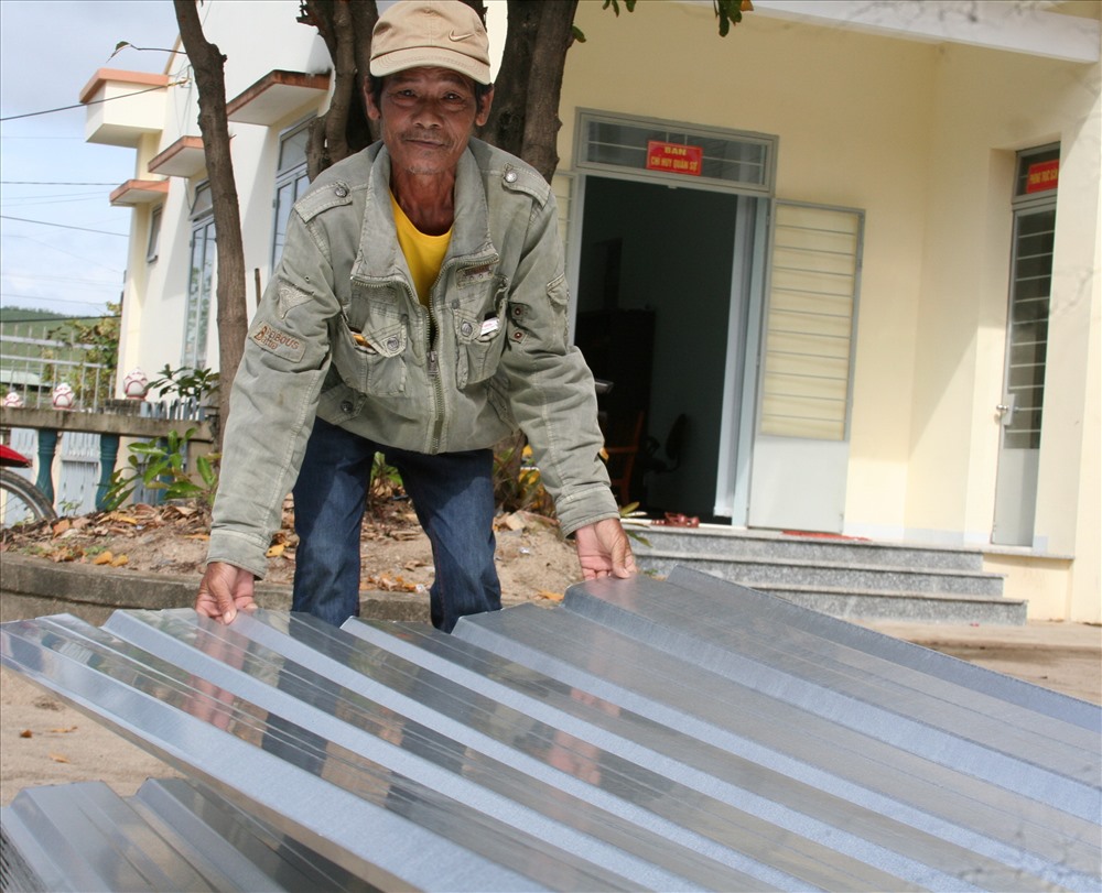 Nhà trước bay hết mái, nhà sau sập vợ chồng ông Nguyễn Văn Hoàng (thôn Tân Mỹ, xã Ninh Phụng, TX Ninh Hòa) cùng 2 cháu đang căng bạt ở tạm trên ngôi nhà đỏ nát “thương 2 đứa nhỏ trời mưa chỗ nào cũng ướt, khổ quá mà mấy hôm nay vay được tiền mua cột tôn thì nhiều quá không biết vay đâu. 8 tấm tôn này là nhà tôi có được nửa cái nhà rồi. Tôi mừng quá, giờ đưa về nhờ người gác lên tạm ở đỡ mưa đã“- ông Hoàng nói. Ảnh: T.Thúy  