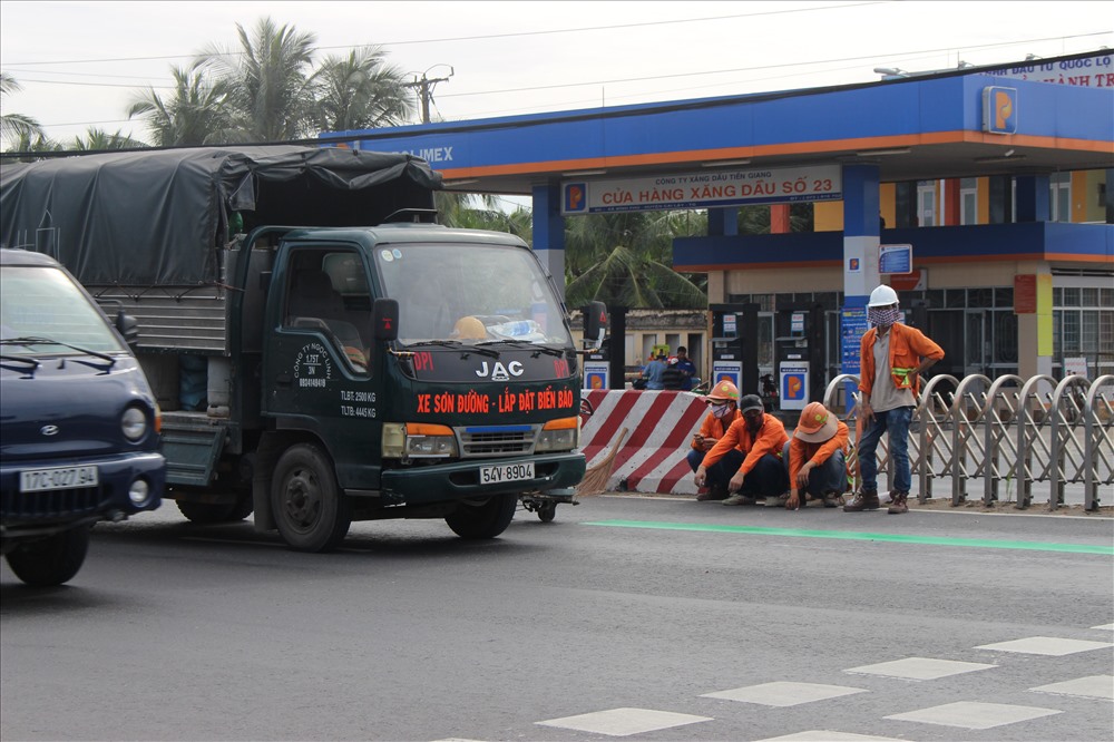 Công nhân sơn kẻ vạch đường trước trạm thu phí.