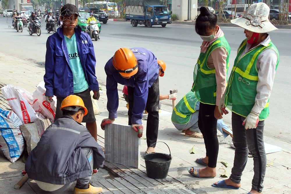 Quận Thanh Xuân đang cho công nhân vá lại vỉa hè.