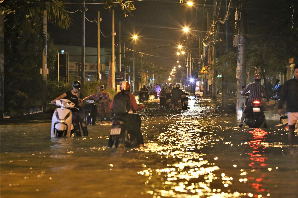 Đoạn đường gần ngã tư Lê Văn Lương - Nguyễn Bình, nước dâng cao hơn 40cm khiến hàng trăm xe chết máy, người dân buộc dầm mình trong dòng nước bẩn để về nhà. Ảnh: Trường Sơn