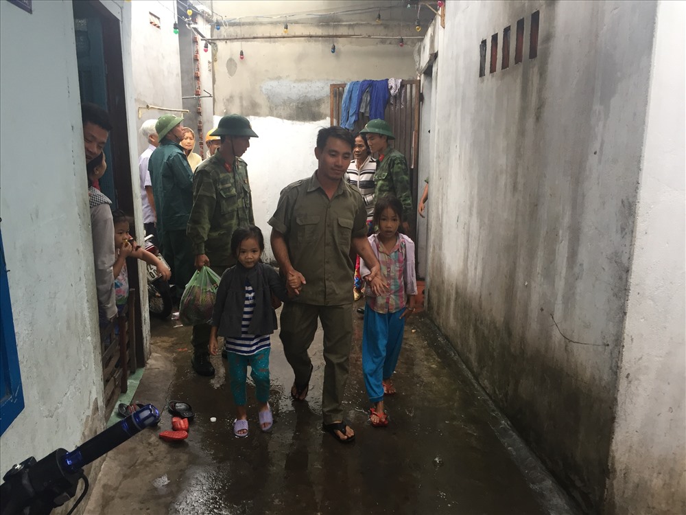 Lực lượng chức năng giúp các em nhỏ và gia đình đi tránh bão 