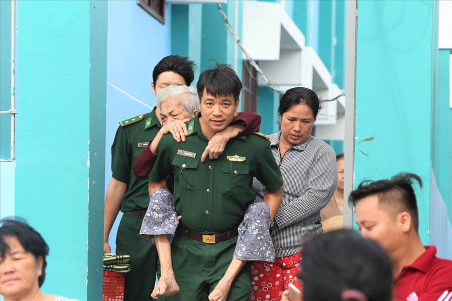 Các lực lượng chức năng hỗ trợ người dân xã đảo Thạnh An, huyện Cần Giờ (TPHCM) rời khỏi nơi trú bão trở về nhà sáng 26.12. Ảnh: TRƯỜNG SƠN