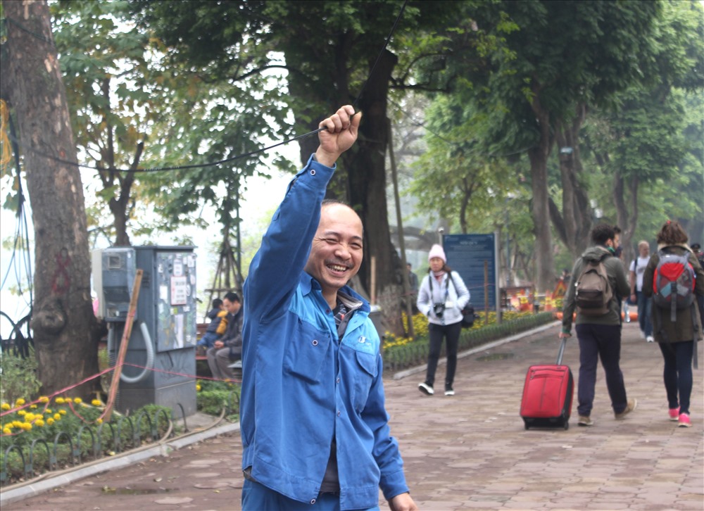 Nụ cười rạng ngời của người công nhân lắp điện chuẩn bị cho chuỗi hoạt động lễ hội đếm ngược lớn nhất Hà Nội trong buổi tối ngày 31.12.