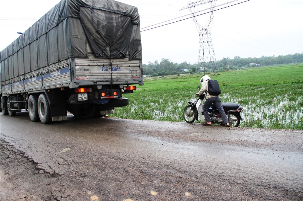 Một người đi xe máy suýt trượt xuống ruộng vì tránh tải lớn. Ảnh: LP