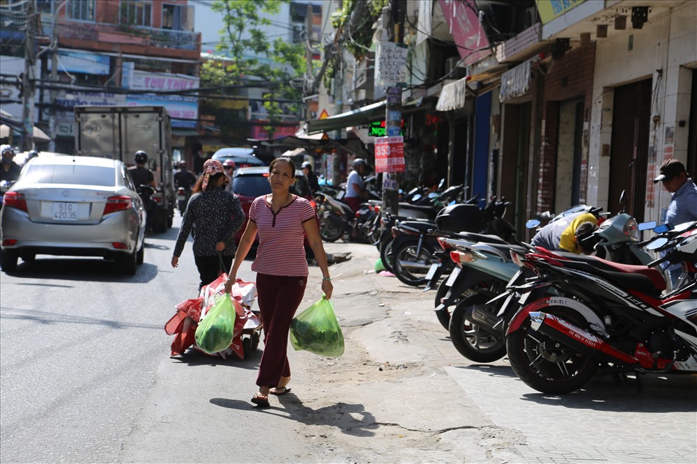 Vỉa hè trên đường Ngô Thị Thu Minh, Q.TB bị chiếm dụng khiến người đi bộ phải xuống lòng đường. Ảnh: Ngọc Tiến