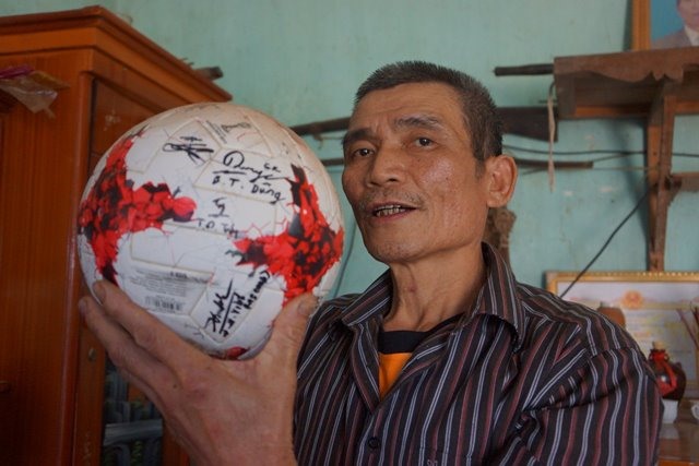 Ông Bùi Văn Khánh - Bố của thủ môn Bùi Tiến Dũng khoe quả bóng vàng của con trai. (Ảnh: HT)