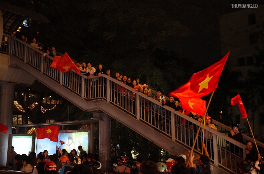 Người dân đứng kín trên cầu vượt để xem màn diễu hành của các CĐV Việt Nam. 