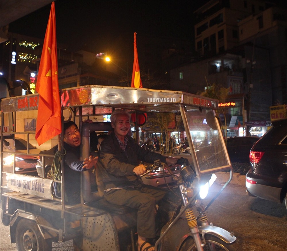 Một chiếc “xe thương binh” gắn cờ đỏ diễu hành.