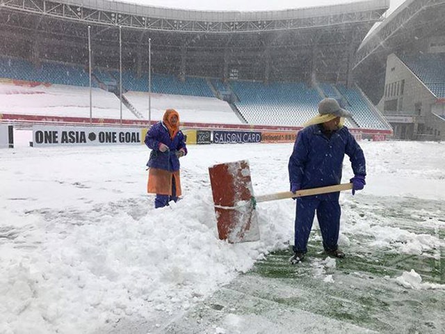 Các công nhân đang tích cực dọn dẹp tuyết rơi để trận chung kết diễn ra đúng với kế hoạch.