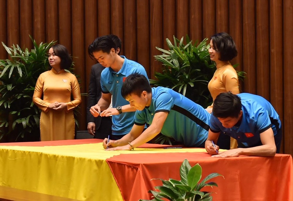 Các cầu thủ đội bóng đá U23 Việt Nam ký vào lá cờ Tổ quốc rộng 54m2 (Ảnh: NB)
