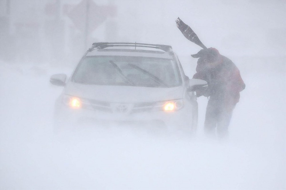 Một người đàn ông cố gắng để chiếc xe của mình bị kẹt trong những điều kiện gần như trắng khi một cơn bão vượt qua Rehoboth Beach, Delaware, vào ngày 4 tháng 1 năm 2018. PHOTO: AFP