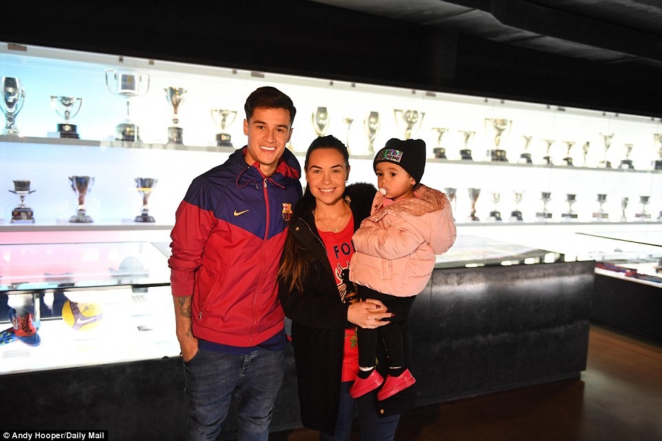 Tiền vệ người Brazil chụp hình cùng cô vợ Aine và con gái Maria, đằng sau là cabin trưng bày các danh hiệu của Barcelona trong lịch sử. Ảnh: Daily Mail.