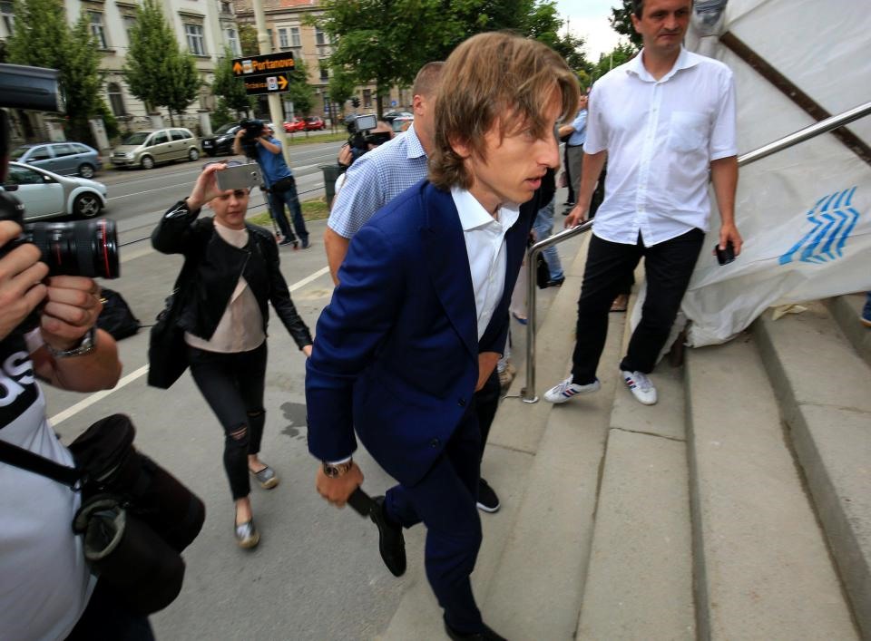 Luka Modric sáng nay trước cửa tòa án cùng với luật sư của mình. Ảnh: EPA.