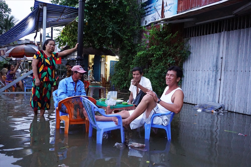 Do đã quá quen với cảnh ngập nước, nhiều người ngồi nhậu giữa lênh láng nước ở Thanh Đa.