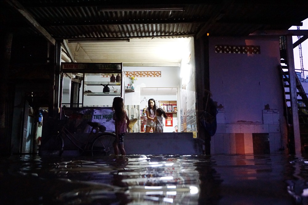 Nước tràn vào tận trong nhà nhưng người dân bất lực bởi dù che chắn thì họ cũng không thể ngăn được dòng nước tràn về từ sông Sài Gòn.