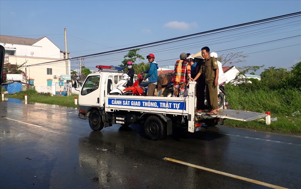 CSGT-TT Thị xã Giá Rai chở xe máy của người dân qua khỏi chỗ ngập nước (ảnh Nhật Hồ)