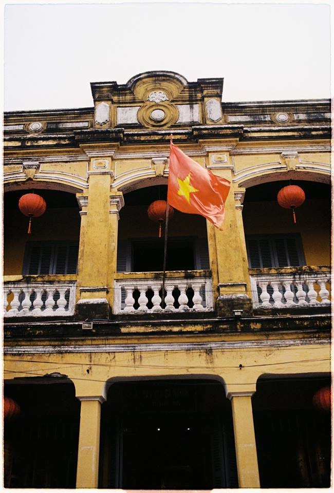 Sắc đỏ của lá cờ Tổ quốc nổi bật trên màu tường vàng cổ kính của Hội An. Ảnh: Hạ Vĩ