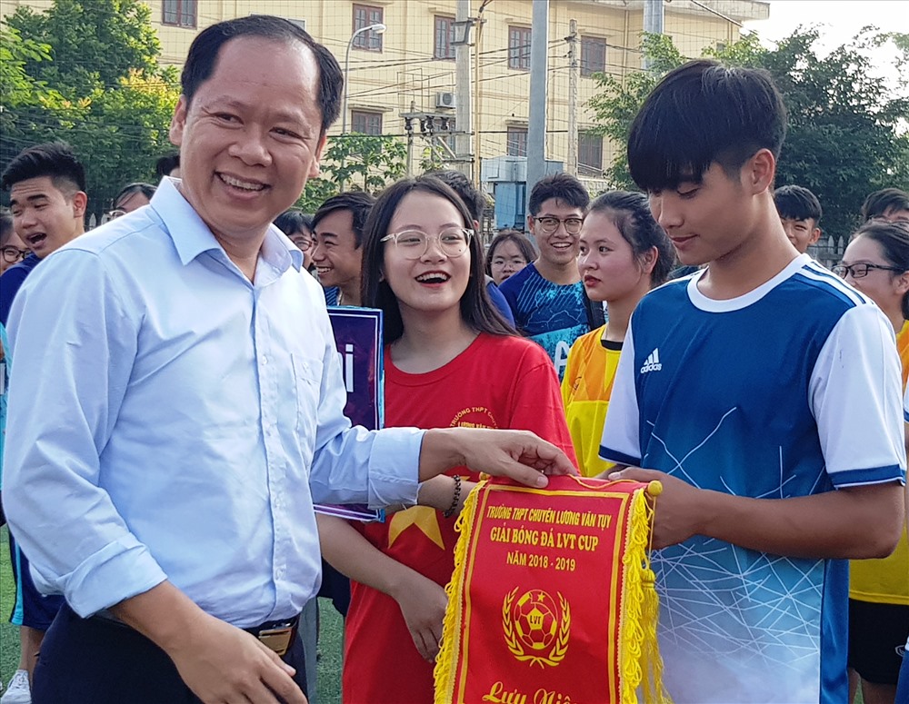 Thầy giáo Đinh Văn Khâm, Hiệu trưởng nhà trường tặng hoa và cờ lưu niệm cho các đội bóng tham dự giải. Ảnh: NT