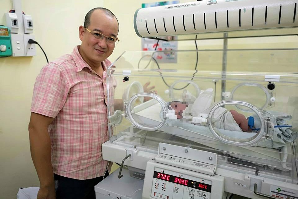 Anh Lê Trung bên em bé được cứu sống hy hữu từ một ca phá thai bằng thuốc. Ảnh: NVCC