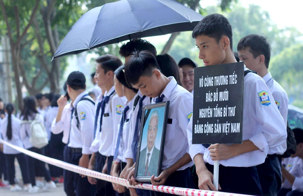  Tại khu vực Ngũ Hiệp (Thanh Trì, Hà Nội), nhiều học sinh tập trung hai bên đường để chờ đoàn xe chở linh cữu nguyên Tổng Bí thư đi qua.