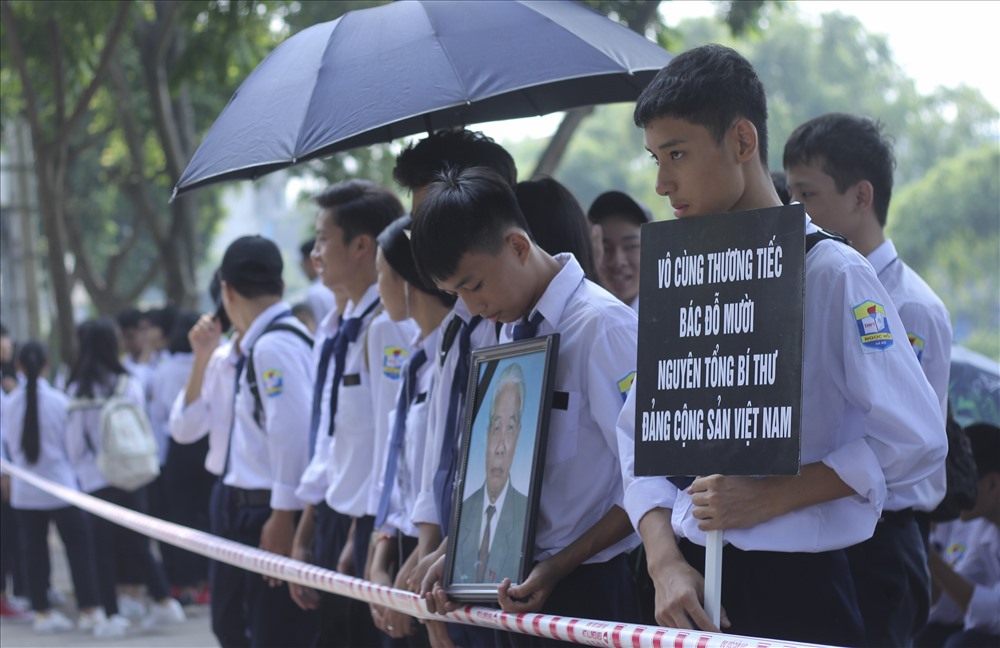 Học sinh mang theo di ảnh và dòng chữ “Vô cùng thương tiếc bác Đỗ Mười - nguyên Tổng Bí thư Đảng Cộng sản Việt Nam“.