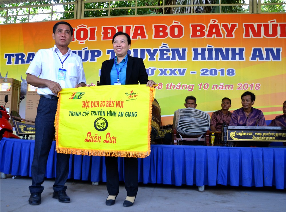 Đại diện huyện Tịnh Biên trao cờ Luân lưu tổ chức Hội đua bò Bảy Núi năm 2019 cho đại diện huyện Tri Tôn. Ảnh Lục Tùng