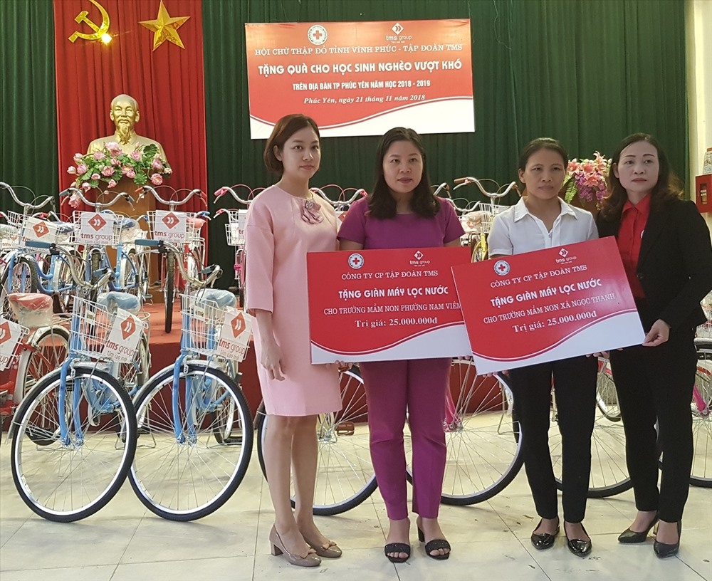 Bà Nguyễn Thủy Tiên - Giám đốc Kinh doanh Tập đoàn TMS (ngoài cùng bên trái) trao máy lọc nước cho 2 trường mầm non