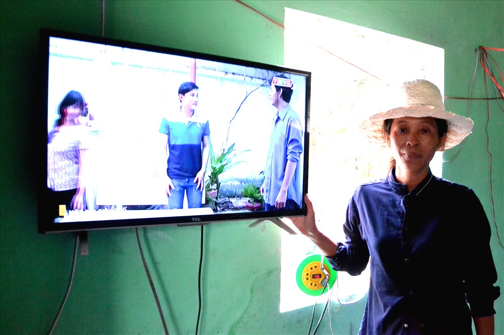 Nhờ sự hỗ trợ của Dự án lần đầu tiên gia đình bà Võ Thị Thúy (ấp Tà Lọt, xã An Hảo) có điện từ hệ thống Pin năng lượng mặt trời để xem ti vi. Ảnh: Lục Tùng