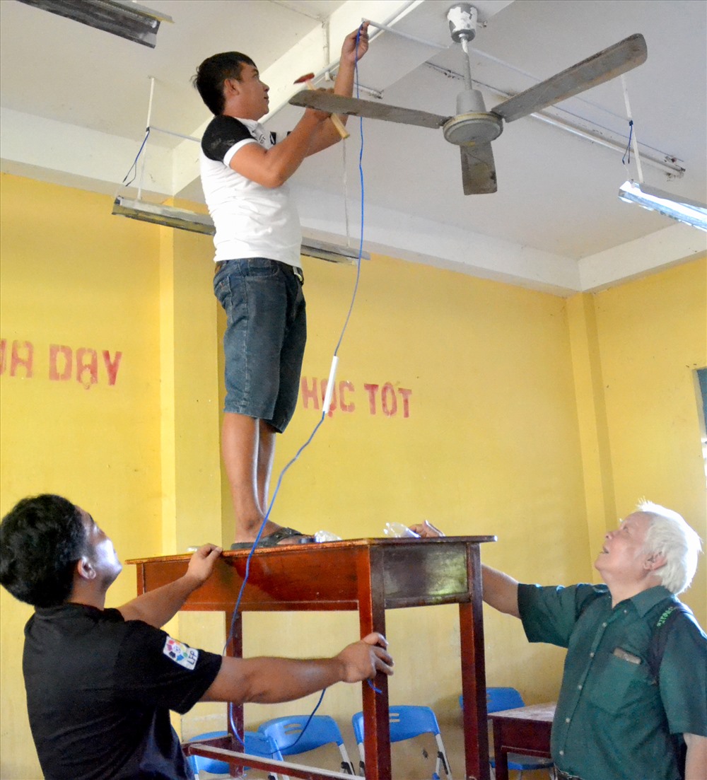 TS Nguyễn Văn Khải trực tiếp hướng dẫn lắp đặt đèn LEB tại trường Tiểu học xã Vĩnh Trung. Ảnh: Lục Tùng