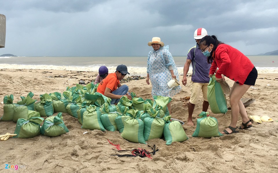 Từ sáng sớm đến trưa nay, người dân TP Nha Trang (Khánh Hòa) đổ xô ra biển xúc cát đổ vào bao tải để về chèn mái nhà ứng phó với bão số 9.(Ảnh: Zing.vn)