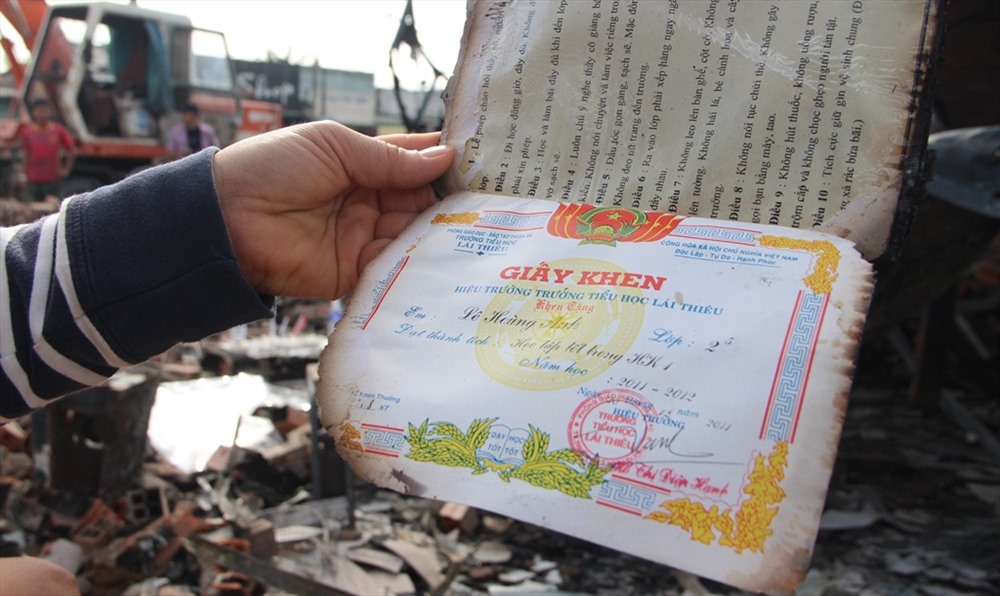 Người dân lật giở giấy khen của một học sinh tử vong trong vụ cháy.