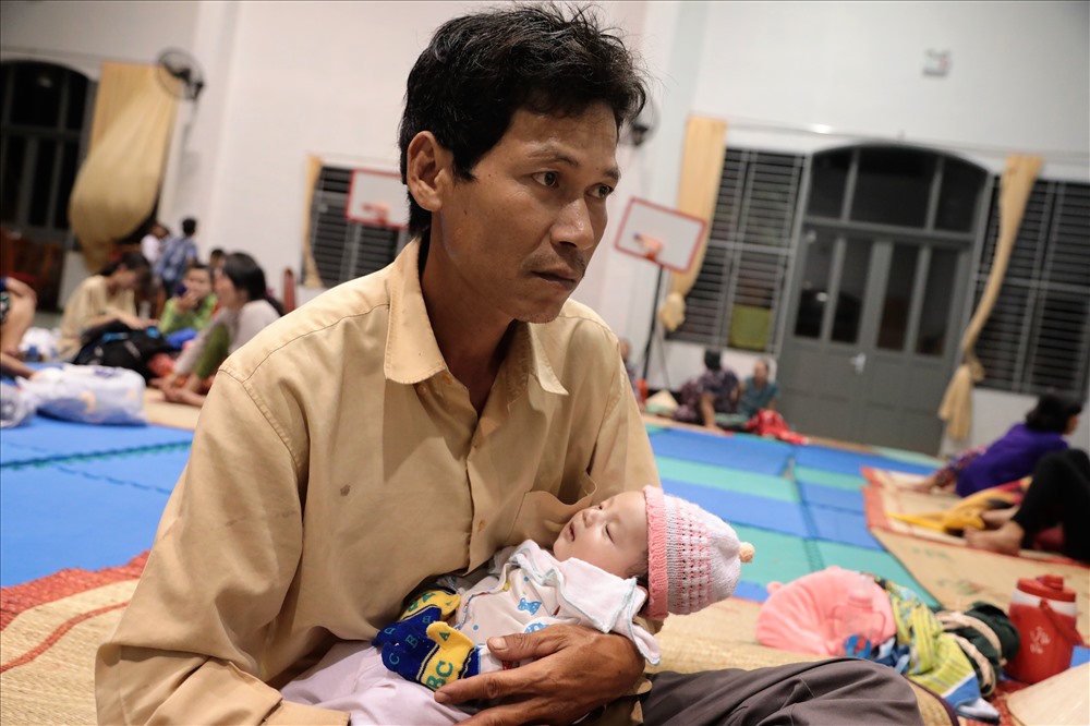Người đàn ông này quê ở Tiền Giang sang Cần Giờ làm thuê. Được chính quyền vận động, anh đưa vợ cùng con mới hơn 1 tháng tuổi đến một điểm trường để trú bão. Ảnh: Trường Sơn