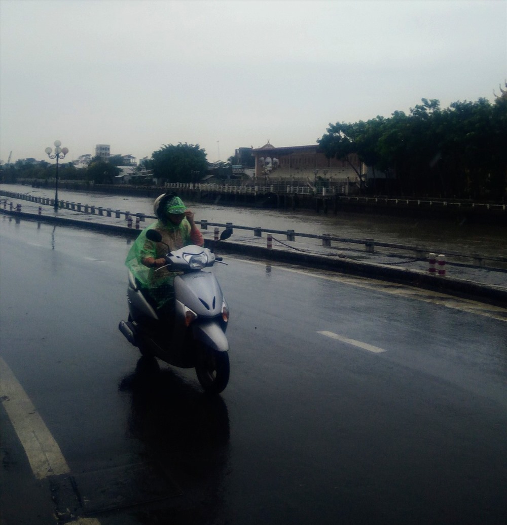 Người dân di chuyển về nhà dưới cơn mưa trong sáng 25.11 tại TP.Trà Vinh