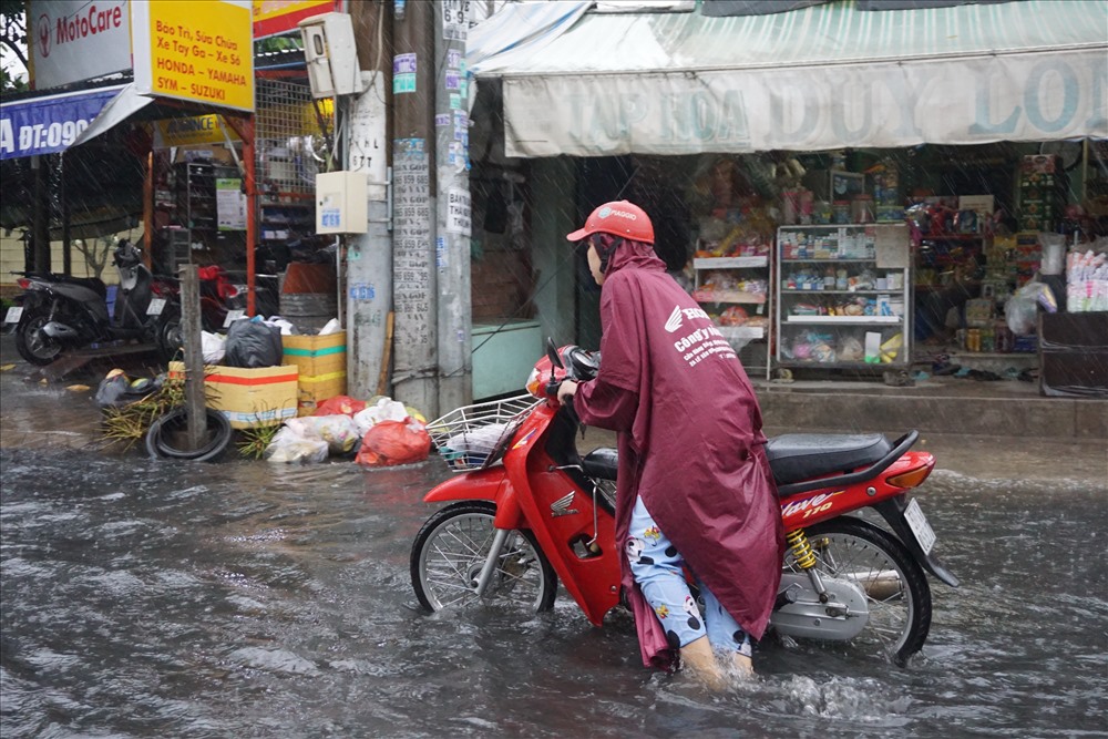 Nhiều người chạy xe máy qua khu vực ngập nước bị chết may xe phải dắt bộ.