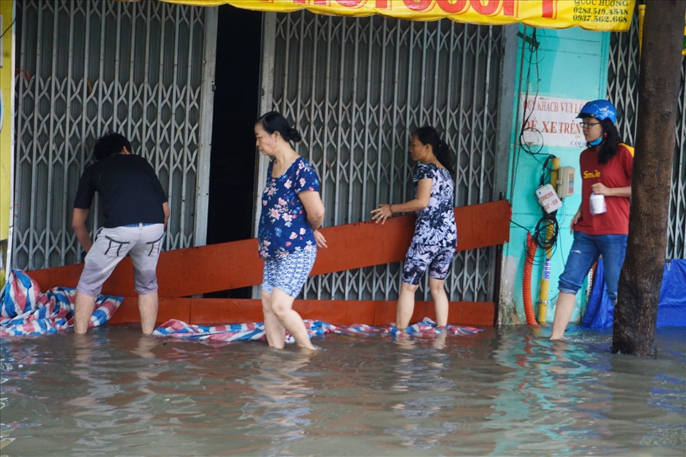 Người dân dùng ván chắn trước nhà để ngăn nước tràn vào trong nhà.