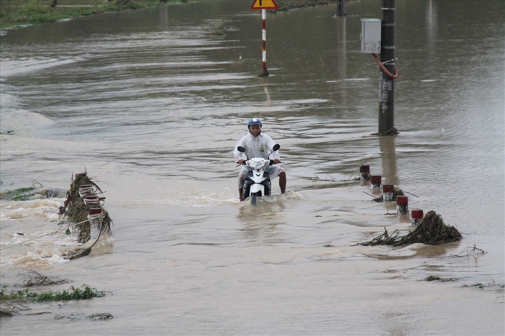 Người dân xã Diên Thạnh, huyện Diên Khánh, Khánh Hòa bất chấp đi lại trong dòng nước siết. Ảnh: Nhiệt Băng
